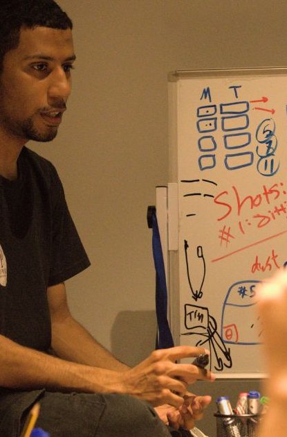 A crew member plans shots on a whiteboard before a session