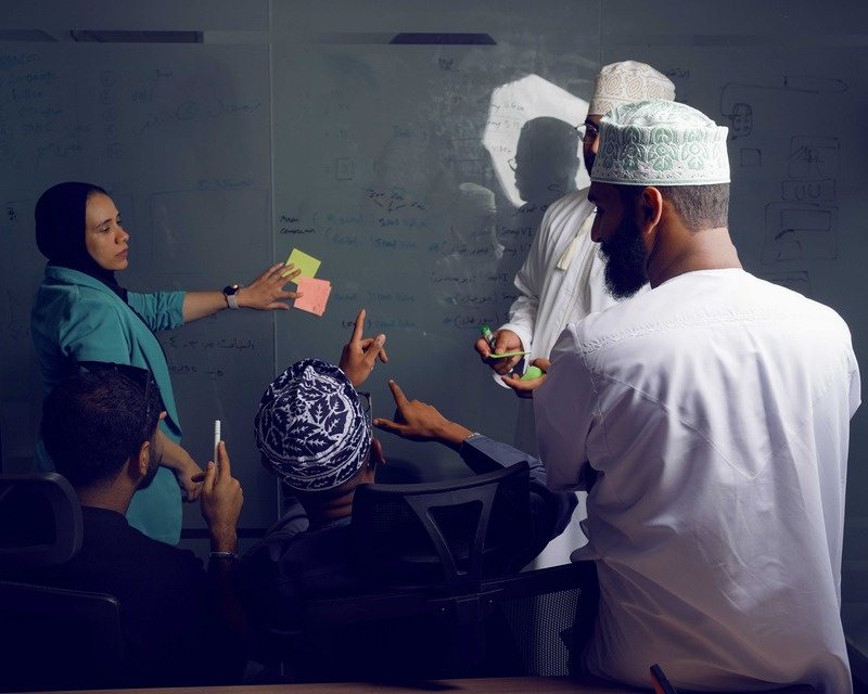 The Limitless Power team sharing ideas around a table covered in sketches