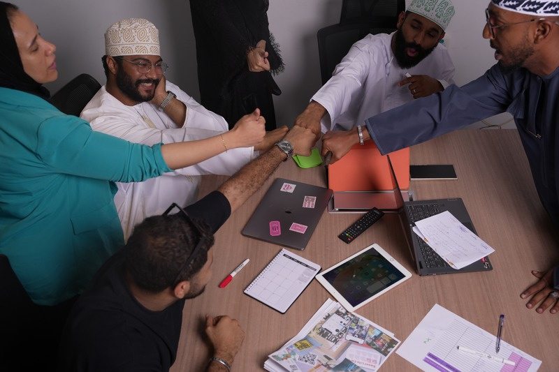 The Limitless Power team planning a campaign around a table of sketches and laptops